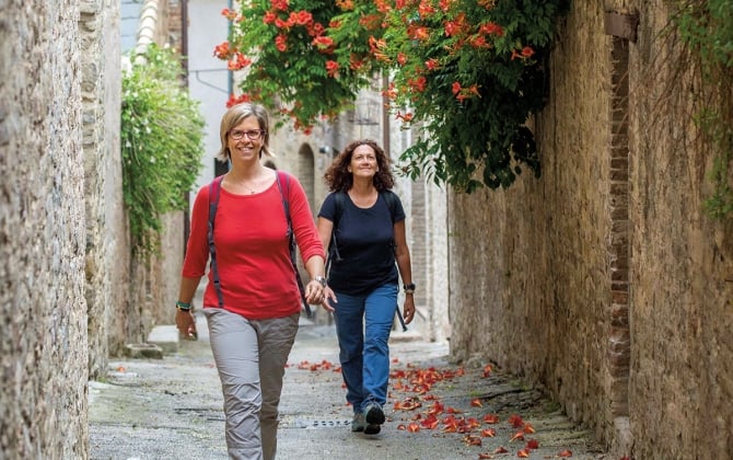 two women walking in a narrow alley