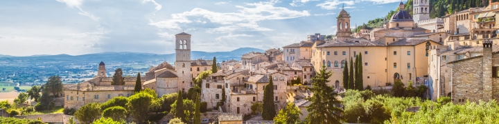 Panoramic view of the historic town of Assisi on a beautiful sunny day with blue sky and clouds in summer, Umbria, Italy