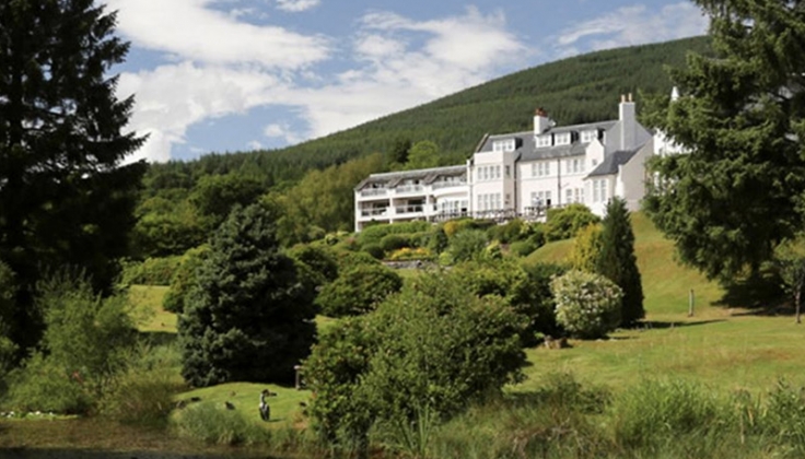 Hotel exterior with forested hill in the background