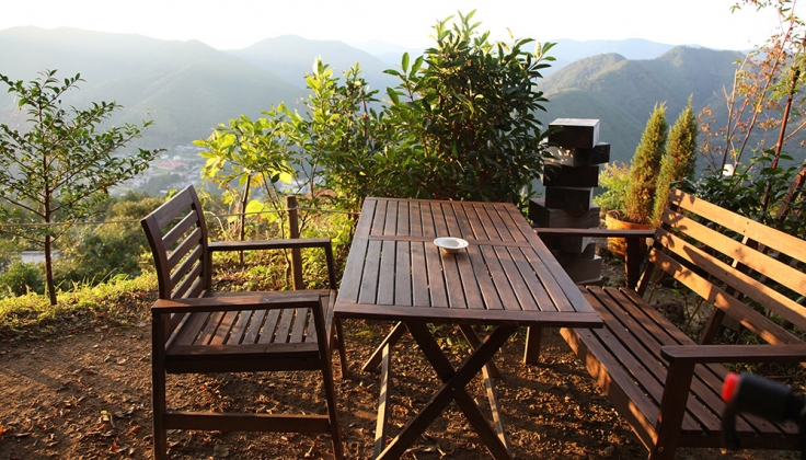 wooden table outside overlooking a forested valley