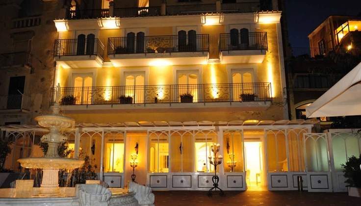 Hotel Villa Fraulo exterior at night with fountain in the foreground