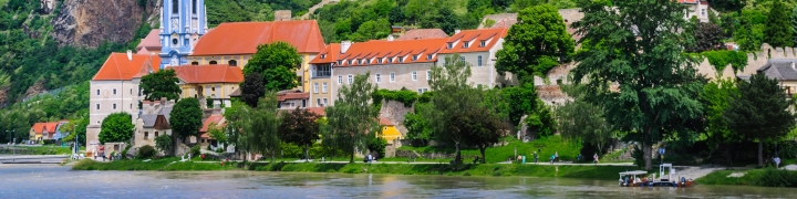 View of the blue and white clock tower of the Durnstein Abbey along the Danube River in lower Austria