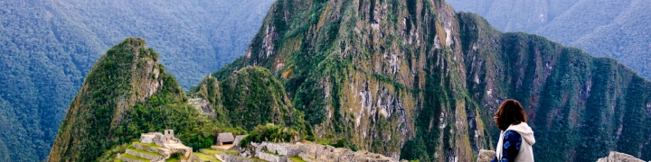 Hiker pausing on a trail with views of Machu Picchu in Peru