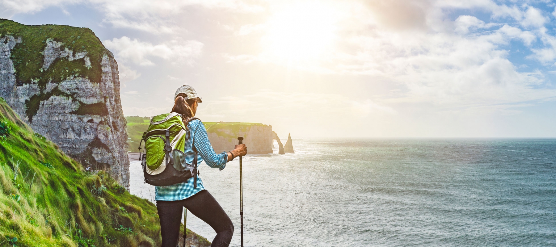 Hiker at the coast line enjoying the view of the sunset and sea